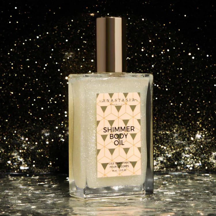 Shimmer body oil in a square glass bottle with gold cap, glittery background