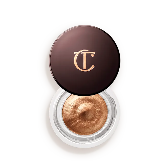 Metallic gold cream eyeshadow in a round jar with a dark brown lid showing gold logo.