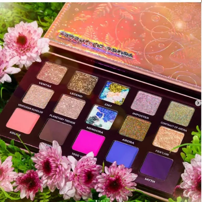 Colorful eyeshadow palette with shimmer and matte shades, surrounded by pink flowers